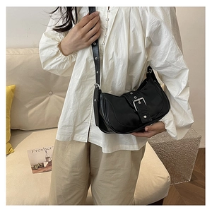 Détail du sac croissant noir avec boucle argentée et bandoulière à œillets réglable