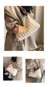 Detail of white quilted underarm bag featuring pink strap and floral charm accessory