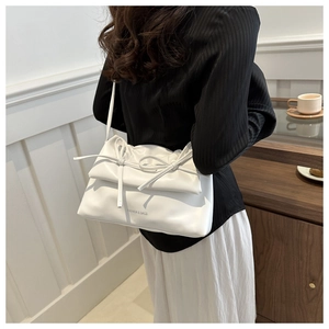 Détail du sac blanc en PU avec nœuds décoratifs et texte Fashion & Bags porté par le mannequin