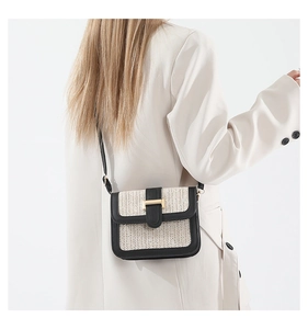 Détail d'un sac bandoulière en paille avec tissage beige et bordures en cuir noir