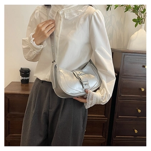 Détail du sac demi-lune argenté avec texture métallique premium et grande boucle élégante