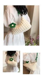 Close-up of white bubble texture fabric and green leather strap with floral charm detail