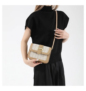 Détail du sac bandoulière en paille contrastée avec bordure en cuir et fermoir en H doré