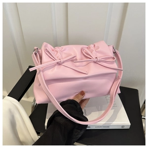 Détail d'un cabas rose en cuir PU avec nœuds et logo mode imprimé sur le fond