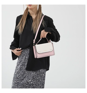 Détail du sac à main bicolore montrant le cuir rose et beige et le logo doré gravé