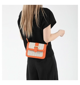 Détail du sac bandoulière avec cuir orange et motif en paille tressée élégant
