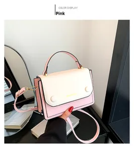 Sac à main en similicuir rose et blanc avec logo doré et poignée ronde en gros plan
