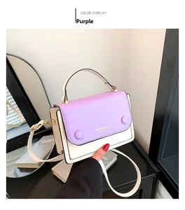 Détail d'un sac à bandoulière bicolore avec rabat en cuir violet et boucles dorées