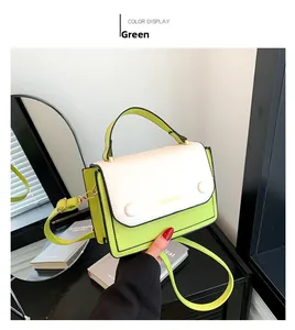 Détail du sac bandoulière bicolore vert lime et blanc cassé avec une large bandoulière