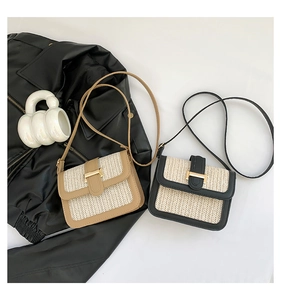 Detail of woven straw flap crossbody bags with contrast leather trim and metal buckles