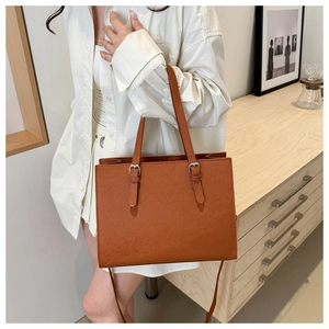Detailed shot of brown PU leather tote bag with adjustable silver buckles for daily work