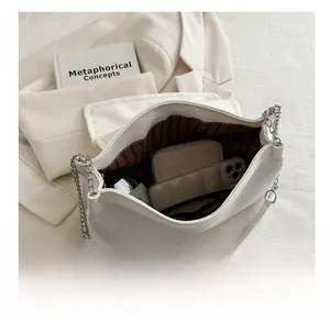 Intérieur spacieux du sac à chaîne en similicuir blanc cassé avec rangement pour mobile