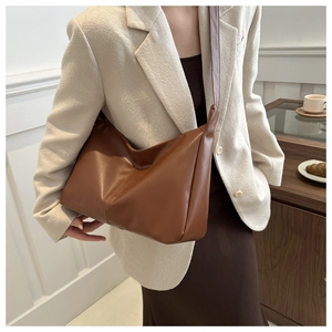 Borsa tote morbida in PU marrone mostrata con modella in un raffinato caffè urbano