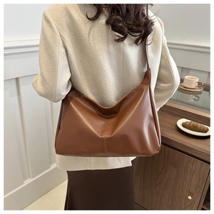 Vista posteriore di una modella con borsa tote in ecopelle marrone con cuciture verticali