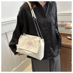 Détail du sac bandoulière en PU blanc cassé avec broderie papillon rose et chaîne