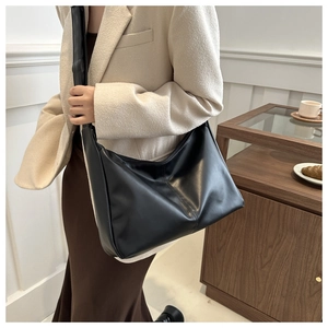 Dettaglio della grande borsa tote in pelle PU nera con cuciture verticali per il pendolare