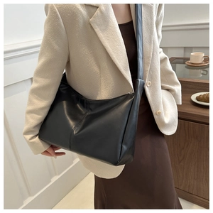 Borsa tote nera minimalista in pelle sintetica indossata da una modella in studio