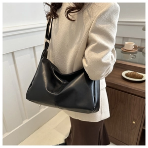 Grande borsa tote nera minimalista con cuciture mostrata in un ambiente di vita quotidiana