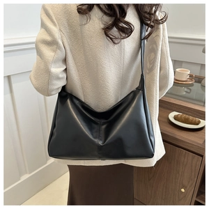 Borsa tote minimalista in pelle PU nera con consistenza morbida indossata da modella
