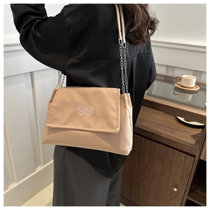 Détail du sac bandoulière kaki avec broderie papillon et bandoulière en chaîne chic