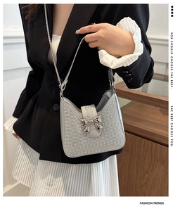 Détail du sac bandoulière argenté à strass avec boucle nœud et chaîne sur mannequin