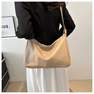 Dettaglio della borsa hobo beige che mostra la texture in pelle morbida e la cucitura centrale