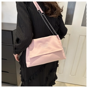 Detailed view of pink crossbody bag with butterfly embroidery and silver metal chain