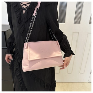 Détail du sac bandoulière en PU rose avec motifs papillons embossés et chaîne en métal
