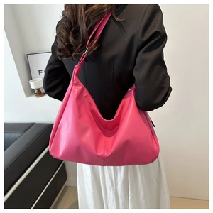Borsa hobo rosa acceso in morbida pelle PU indossata dal modello con design minimalista