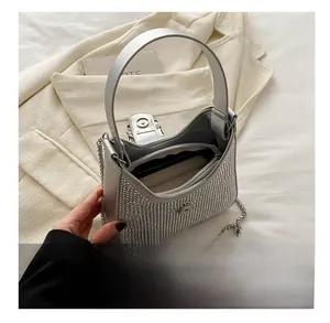 Vue intérieure du sac argenté en strass montrant la poche zippée et le rangement quotidien