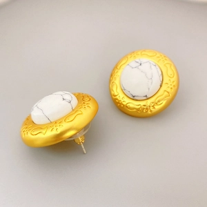 Vintage matte gold earrings with fish relief and white turquoise stone, 45-degree angle view