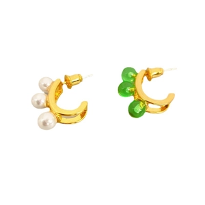 Asymmetric C-shaped gold earrings set with white pearls and translucent green beads