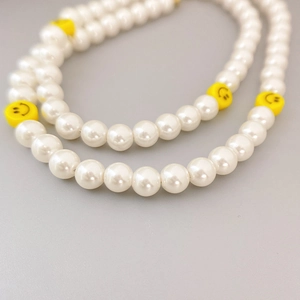 Elegant pearl necklace with yellow smiley face beads for a fresh and stylish summer look