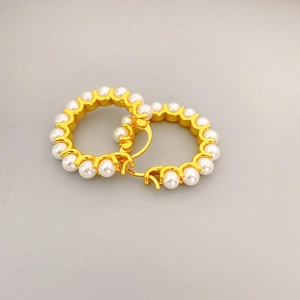 Elegant gold-tone circular hoop earrings featuring multiple white pearls on grey background