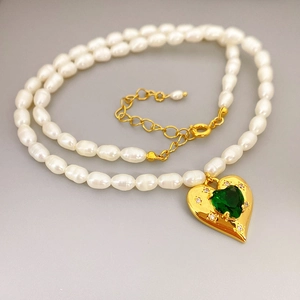 Elegante Perlenhalskette mit goldenem Herzanhänger und grünem Edelstein besetzt