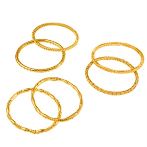 Set of seven gold titanium steel bangles with diverse textured geometric patterns