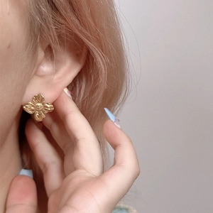 Textured gold flower stud earrings in stainless steel for a minimalist floral aesthetic