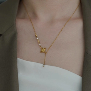 Elegante 18K vergoldete Kleeblatt-Perlenkette mit Quaste an einem Model