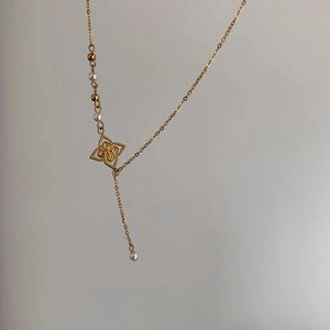 Detail der 18K vergoldeten Kleeblatt-Kette mit langem Quastenanhänger und Perlen