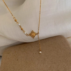 Detail der 18K vergoldeten Kleeblatt-Halskette mit eleganten Perlen-Quastenanhängern