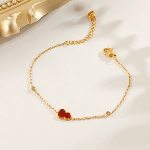 Elegant gold bracelet with red gourd-shaped pendant and white zircon accents on light background