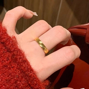 Close-up of gold-plated titanium ring with concentric wave textures worn on finger