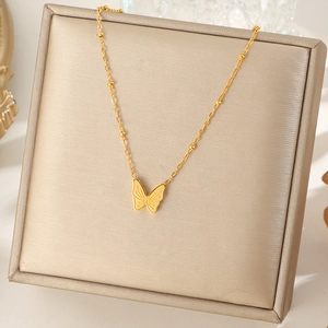Collana minimalista con ciondolo a farfalla dorata e catena a sfere su espositore