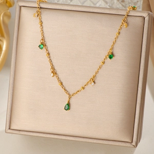 Collier en titane plaqué or 18k avec pendentif goutte d'émeraude sur boîte à bijoux