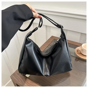 Dettaglio della borsa hobo in morbida pelle PU nera con cerniera in metallo e texture
