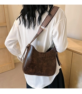 Detail der dunkelbraunen Hobo-Tasche mit ethnisch gewebtem breitem Schultergurt