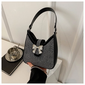 Détail du sac noir avec strass argentés et boucle en métal en forme de nœud papillon