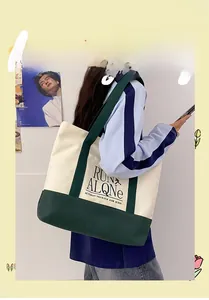 Model wearing a large color-block canvas tote bag with green straps and Run Alone text