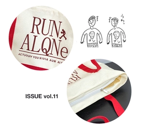 Detail of red webbing handles and zipper closure on a canvas tote with run alone print