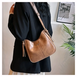 Vintage-Hobo-Tasche aus braunem Leder mit geometrisch gewebtem Schultergurt in Detailansicht